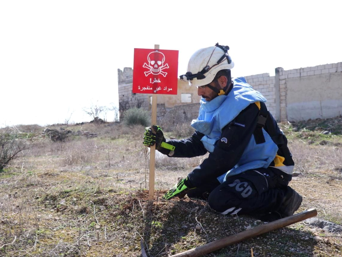 A White Helmets volunteer removes military debris.