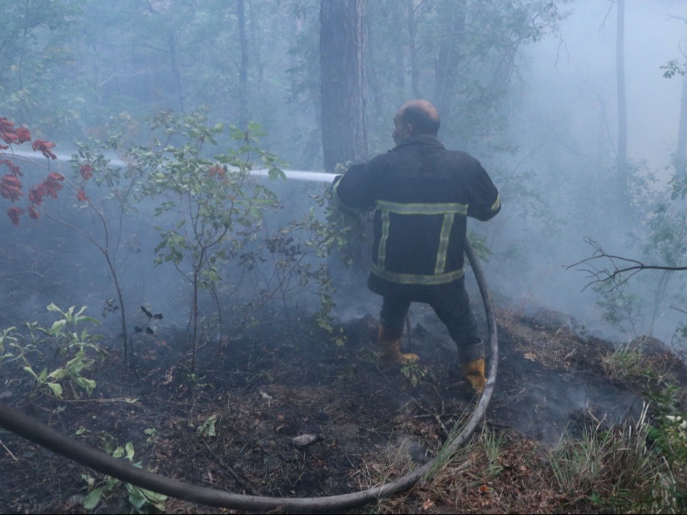 متطوع في فرق الإطفاء أثناء إخماد الحرائق في ريف اللاذقية